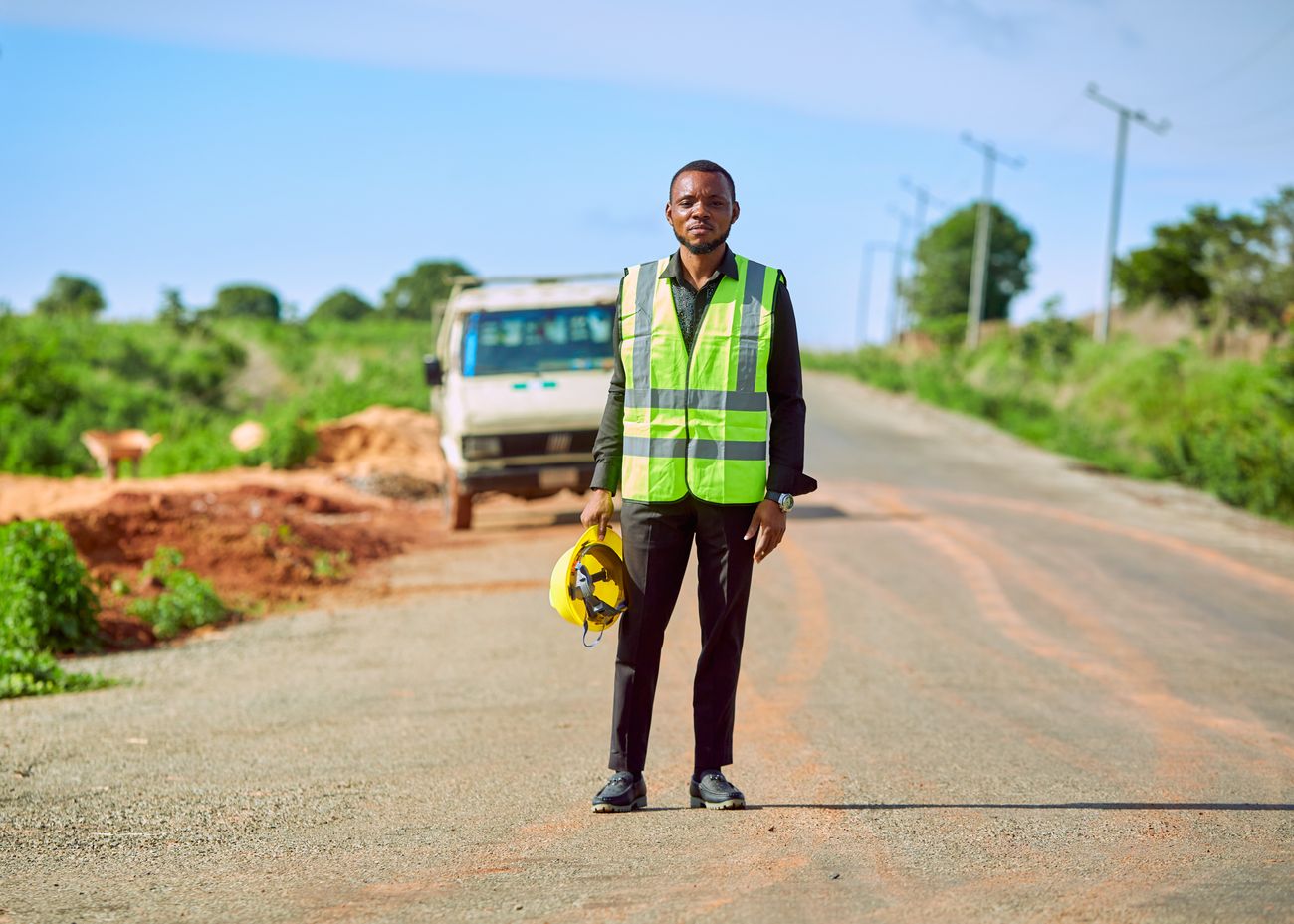 Agent de chantier en gilet sur une route rurale à Lafia, Nigeria